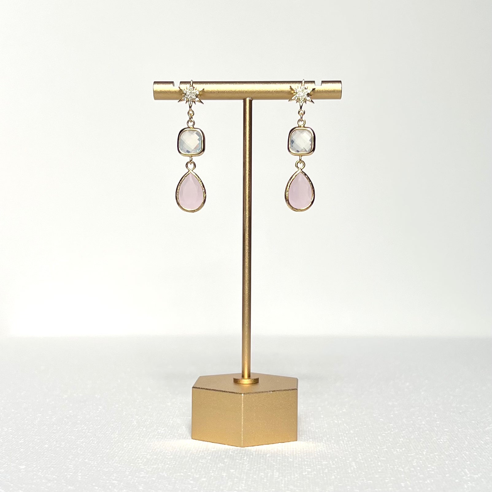 This earring set features a white square glass bezel charm with a pink glass teardrop shape bezel charm hung by a CZ crested gold filled star shaped earring post.
