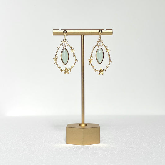 This earring set features a gold branch &amp; flower hoop in which hangs a minty green glass marquise shaped bezel set charm, hung on a gold filled 4mm ball stud earring post.&nbsp;